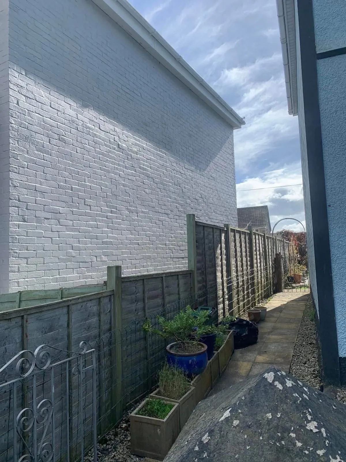 Freshly painted brick wall after preparation and masonry paint in Totnes